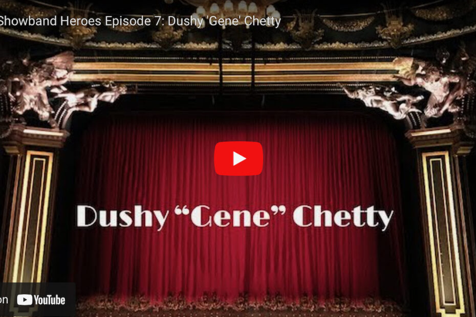 An image of red velvet curtains on an ornate stage with a YouTube play button superimposed and the text 'Dushy "Gene" Chetty'